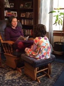 mother reading to 5-year-old girl