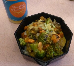 jar of Simply Balanced Panang Ginger Curry Sauce alongside bowl of vegetables, lentils, and rice topped with the sauce