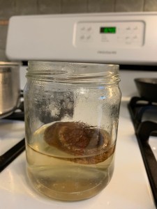 mushrooms soaking in a jar of water, which has turned pale brown