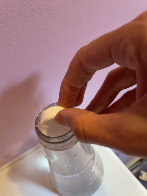 dropping tablet into bottle of water